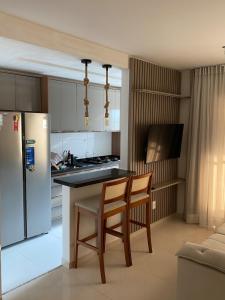a kitchen with a refrigerator and a table and chairs at Refúgio Aconchegante & Charmoso! in Aracaju