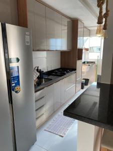 a kitchen with white cabinets and a refrigerator at Refúgio Aconchegante & Charmoso! in Aracaju +7 photos