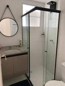 a bathroom with a shower with a sink and a mirror at Refúgio Aconchegante & Charmoso! in Aracaju
