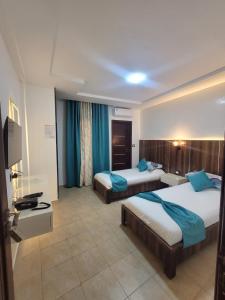 a hotel room with two beds and a television at Impavid Hotel in Gabès +52 photos
