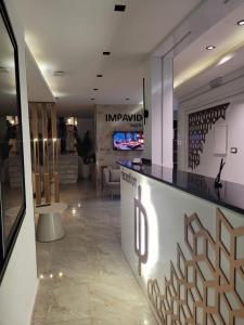 a lobby with a counter with a tv in the background at Impavid Hotel in Gabès