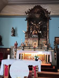 a altar in a church with a clock on the wall at Entre sarre et albe in Sarralbe