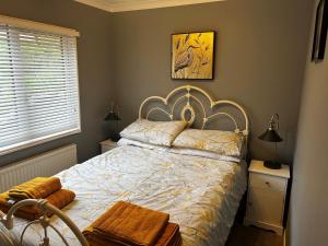 a bedroom with a bed and a chair and a window at 22 Two Little Ducks in Lynton