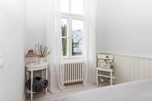a bedroom with a bed and a window with curtains at Linda Külaliskorter in Haapsalu