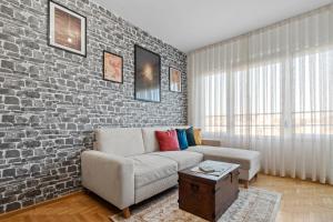 a living room with a couch and a brick wall at Wizard's apartment Plovdiv in Plovdiv