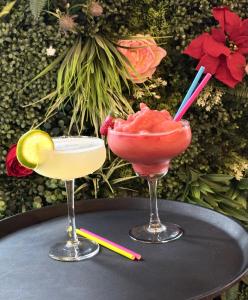 two cocktails sitting on a table with flowers at Amorist Hotel in Dunfermline +32 photos