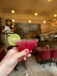 a person holding a pink drink with a lime at Amorist Hotel in Dunfermline