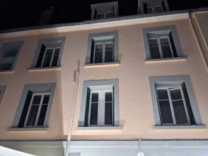 a white building with six windows on it at Hotel BETHEL in Nevers