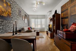 a living room with a table and a brick wall at Wizard's apartment Plovdiv in Plovdiv +17 photos
