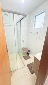 a bathroom with a glass shower and a sink at Casa para 9 pessoas a poucos passos do Santuário de Aparecida in Aparecida