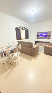 a living room with a couch and a tv at Casa para 9 pessoas a poucos passos do Santuário de Aparecida in Aparecida