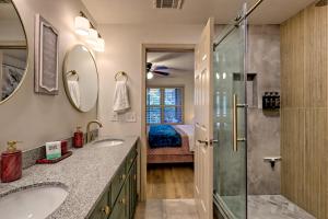 a bathroom with two sinks and a shower and a bed at Alpine Studio in Helen