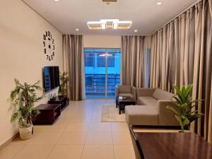 a living room with a couch and a tv at Aspire Tower in Manama