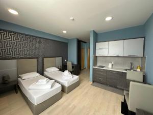 a room with two beds and a sink and a kitchen at Koncept RK in Banja Luka