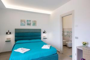 a bedroom with a blue bed and a bathroom at Villavità in Agerola