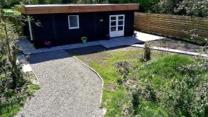 a small shed with a white door in a yard at BenB Tuskendepade in Oldeholtpade