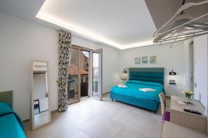 a bedroom with a blue bed and a balcony at Villavità in Agerola