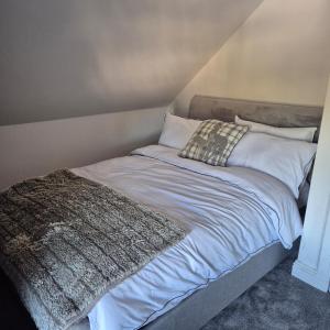 a bed with a blanket and pillows on it at Lochmaben in Lochmaben