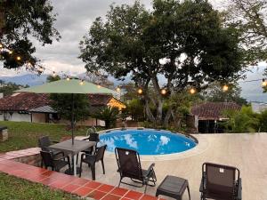 a patio with a table and chairs next to a pool at La Cabaña Socorro in Socorro