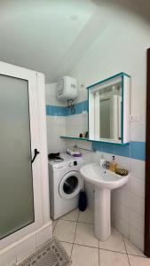 a bathroom with a washing machine and a sink at Holiday Properties, Ilha do Fogo in Santa Maria +38 photos
