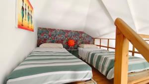 two twin beds in a room with a staircase at Holiday Properties, Ilha do Fogo in Santa Maria