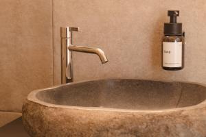 a bathroom sink with a soap bottle on a wall at Chalet Ferienwohnung zwischen Berchtesgaden und Ramsau in Bischofswiesen