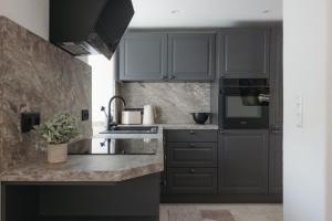 a kitchen with gray cabinets and a sink at Chalet Ferienwohnung zwischen Berchtesgaden und Ramsau in Bischofswiesen