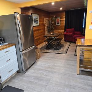a kitchen with a stainless steel refrigerator and a table at Ocean's Edge in Port Alice