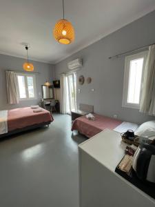 a room with two beds and a desk in it at Passos Rooms in Parikia