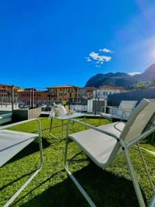 a patio with a table and chairs on the grass at Apt Pisces - Oasi di Menaggio in Menaggio