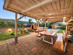 an outdoor patio with a wooden pergola at Holiday home Melani - with private heated pool and sauna in Sinac