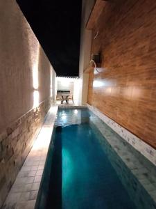 a swimming pool with a bench in a building at Samburá Residece By 123Quarto in Camalaú