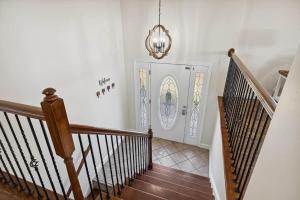 a hallway with stairs and a white door with a chandelier at Spacious 4 bd with hottub, theater & game zone in Union Grove