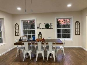 a dining room with a table and chairs and windows at Spacious 4 bd with hottub, theater & game zone in Union Grove