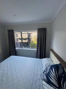 a bedroom with a bed and a window at Spacious One-Bedroom with Private Bathroom Aotea in Porirua