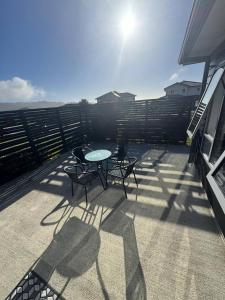 a patio with a table and chairs on a balcony at Spacious One-Bedroom with Private Bathroom Aotea in Porirua