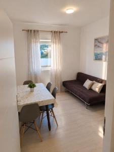 a living room with a table and a couch at Apartmani Kasteljan 5,Stara Novalja in Stara Novalja