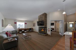 a living room with a couch and a fireplace at Prestige Prince George Lodge in Prince George