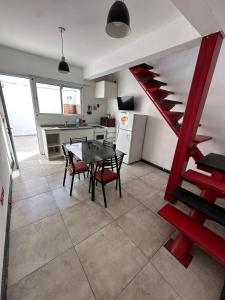 a kitchen with a red staircase and a table and chairs at Mini casita a in Rosario