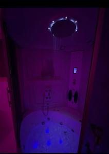 a dark bathroom with a tub in a purple room at Safety house in Tabuk