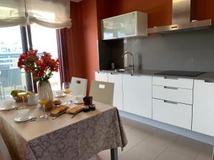 a kitchen with a table with a vase of flowers and wine glasses at CANELAS CLASS con AMPLIAS TERRAZAS in Portonovo