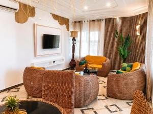 a living room with wicker chairs and a television at Kaz An Nou in Kika