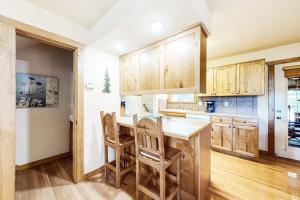 a kitchen with wooden cabinets and a table and chairs at Beautiful Branson in Branson West +36 photos