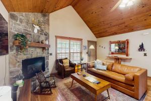 a living room with a couch and a fireplace at Woodland in Branson West