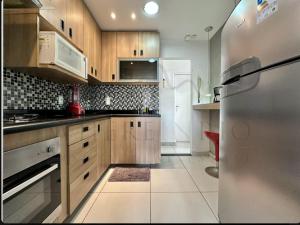 a kitchen with wooden cabinets and a stainless steel refrigerator at Best 2 bedroom condo 3 bathroom in Rio de Janeiro +10 photos