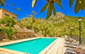 a swimming pool with chairs and mountains in the background at Biniforani Nou in Bunyola