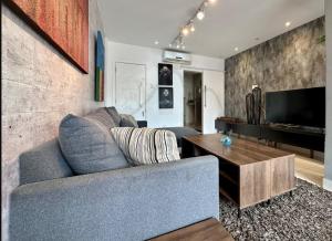 a living room with a blue couch and a television at Best 2 bedroom condo 3 bathroom in Rio de Janeiro