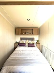 a bedroom with a large bed with purple pillows at Primrose View in Filey