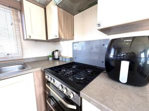 a kitchen with a stove and a microwave at Primrose View in Filey +62 photos