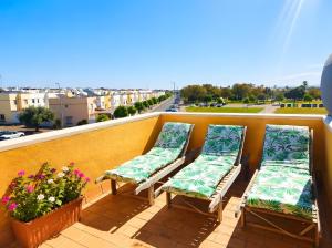 three chairs on a balcony with a view of a city at El Rincón Sevillano in Gerena